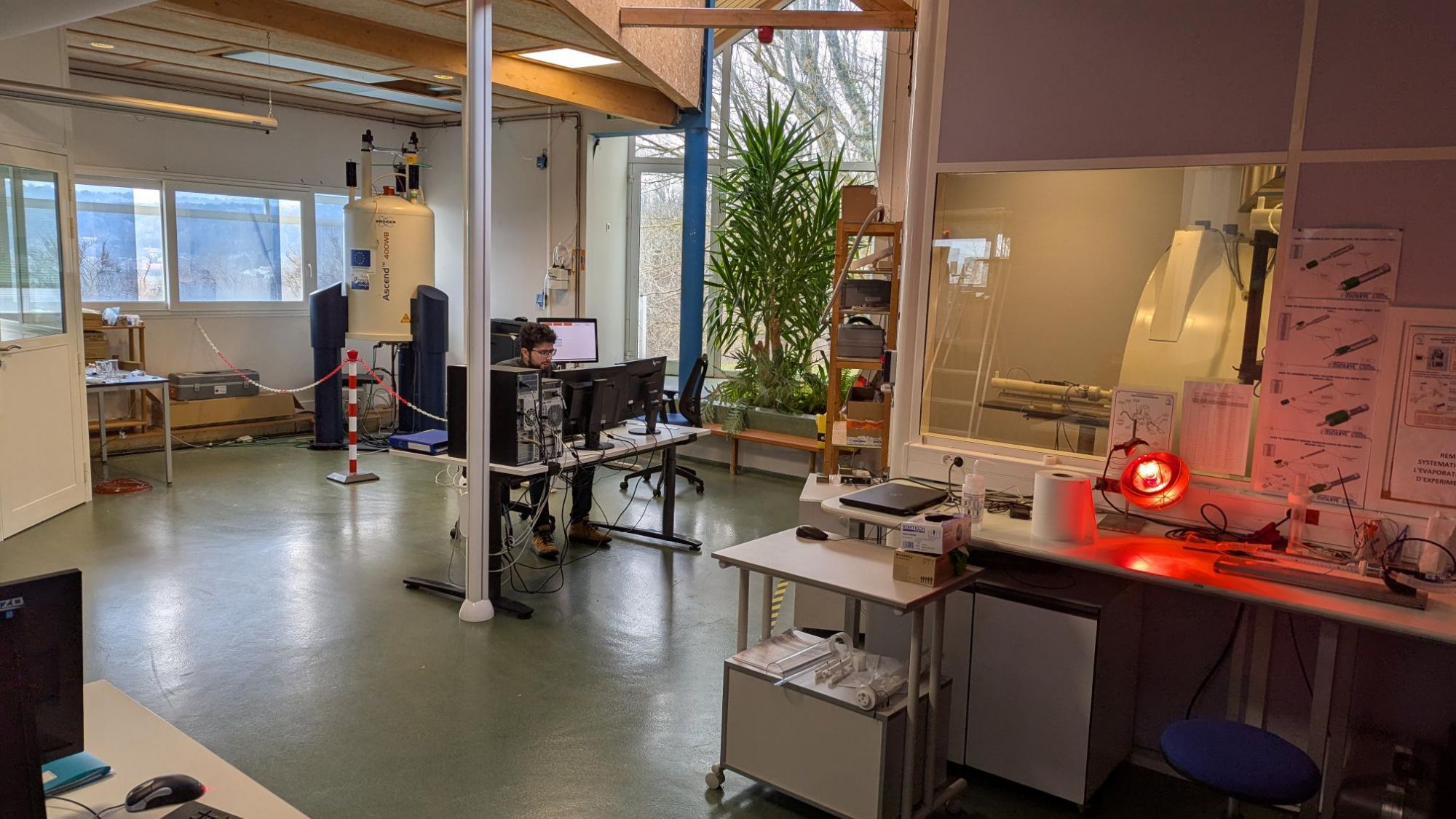 Vue globale de la salle des spectromètres de la plateforme AgroResonance. Un collègue travaille devant l'une des consoles.